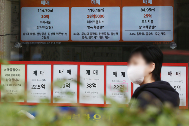 한 시민이 공인중개사무소 앞을 걸어가고 있다./연합뉴스