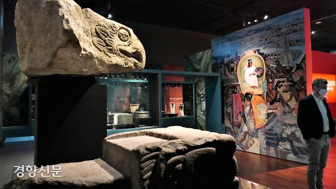 아스테카 문화에서 독수리는 태양을 상징한다. 왼쪽 위 ‘독수리 머리’(1350~1521쯤). 아래 조각 ‘뱀 머리 모양 건축 장식’(1350~1521년쯤)이다. 뱀은 대지의 신과 관련 있는 신성한 동물로 여겨졌다. 맞은 편 벽화(복제)는 디에고 리베라(1929~1935)의 ‘멕시코의 역사’ 중 ‘틀라텔로코 시장’이다. 이 시장은 테노치티틀란의 상업 중심지였다. 김종목 기자