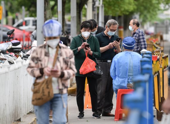 일부 이동제한이 풀린 중국 상하이 자딩구에서 10일시민들이 시장에 들어가기 전에 코로나10 핵산검사 증명서를 보여주고 있다. /사진=신화뉴시스