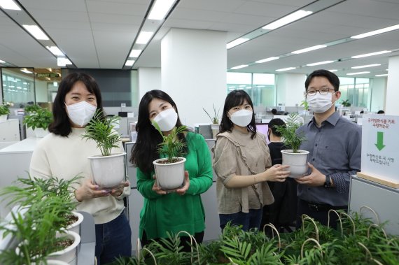 LG이노텍 직원들이 사내 비대면 봉사활동인 '공기정화 식물 기부'에 참여하고 있다. LG이노텍 제공