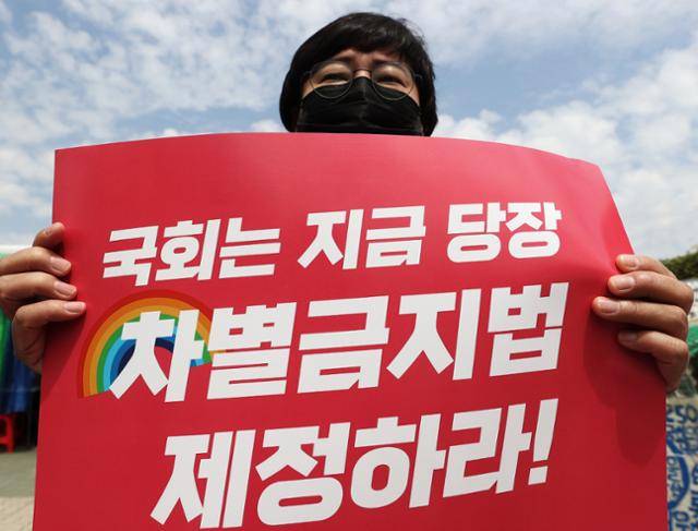 전국교수노동조합, 민주평등사회를 위한 전국 교수연구자협의회(민교협) 등 관계자들이 13일 서울 영등포구 국회 정문 앞에서 열린 차별금지법 제정 촉구 기자회견에서 손팻말을 들고 있다. 연합뉴스