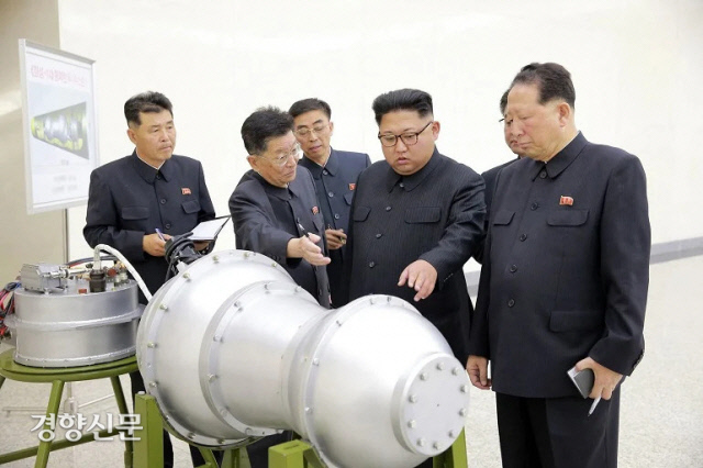 김정은 북한 국무위원장(오른쪽 두 번째)이 핵탄두 모형을 살펴보고 있다. 북한은 2017년 9월 3일 6차 핵실험 이후 이 사진을 관영 언론을 통해 공개했다. 연합뉴스
