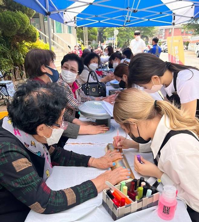 수성대 뷰티스타일리스트과 전공동아리 마뀌아쥬 회원과 교수들이 범물복지관에서 미용 재능기부를 하고 있다. (수성대 제공) 2022.05.17