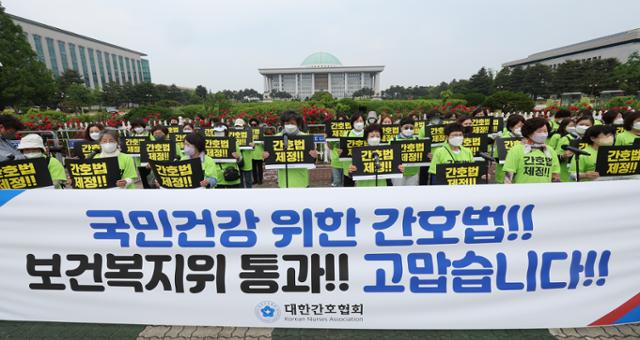 대한간호협회 관계자들이 18일 서울 국회 앞에서 간호법 국회 보건복지위 통과 환영 집회를 하고 있다. 연합뉴스
