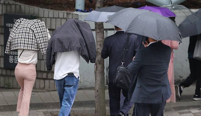 출근길 소나기…우산 대신 옷으로 서울에 소나기가 내린 18일 우산을 준비 못한 시민들이 지하철 교대역 인근에서 겉옷을 뒤집어쓴 채 출근길을 서두르고 있다. 연합뉴스