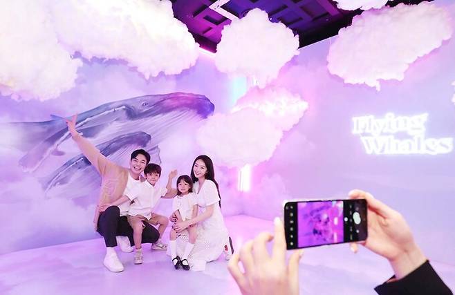 17일 서울 송파구 롯데월드타워 서울스카이에서 가족들이 미디어아트 특별전 '나는 고래' 포토존에서 사진을 찍고 있다.