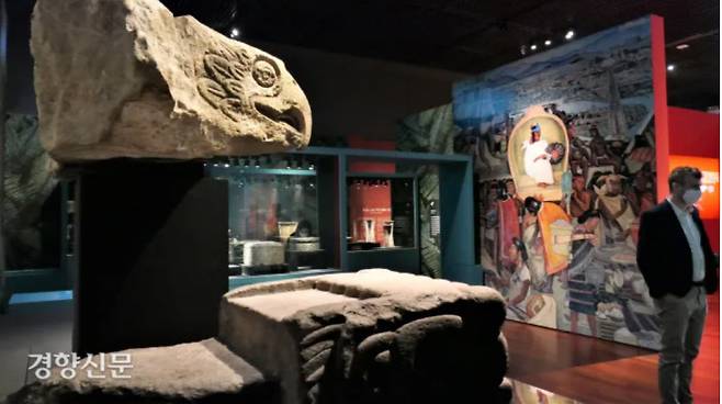 아스테카 문화에서 독수리는 태양을 상징한다. 왼쪽 위 ‘독수리 머리’(1350~1521쯤). 아래 조각 ‘뱀 머리 모양 건축 장식’(1350~1521년쯤)이다. 뱀은 대지의 신과 관련 있는 신성한 동물로 여겨졌다. 맞은 편 벽화(복제)는 디에고 리베라(1929~1935)의 ‘멕시코의 역사’ 중 ‘틀라텔로코 시장’이다. 이 시장은 테노치티틀란의 상업 중심지였다. 아스테카전은 21일 임시 휴관한다. 김종목 기자