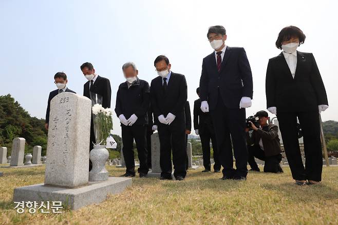 서울 동작구 국립서울현충원 내 5·18 민주화 운동 당시 시위 진압에 참여했다가 돌진한 버스에 의해 사망한 경찰의 묘 앞에서 버스 운전 가해 당사자가 배모씨(왼쪽 세번째)와 유가족들이 참배하고 있다. 권도현 기자