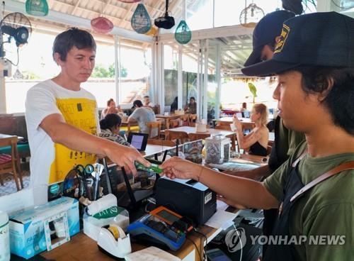 인도네시아 발리의 카페에서 신용카드 사용 시도하는 러시아인 [로이터 연합뉴스 자료사진. 재판매 및 DB 금지]