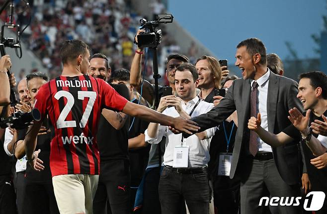 아버지인 파올로 말디니(오른쪽)와 악수하는 다니엘 말디니. © 로이터=뉴스1