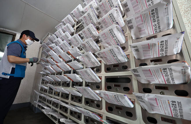 제8회 전국동시지방선거를 열흘 앞둔 22일 오전 서울 강서구의 한 아파트에서 집배원이 투표안내문 및 선거공보물을 우편함에 넣고 있다. 연합뉴스
