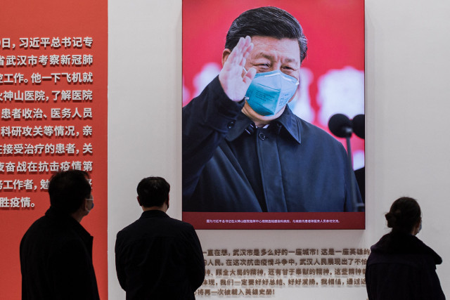 작년 1월 15일 중국 후베이성에 있는 우한 컨벤션 센터에서 열린 중국의 코로나19 퇴치를 주제로 한 전시회에 방문한 사람들이 마스크를 쓰고 있는 시진핑 중국 국가 주석의 사진을 보고 있다. 제로 코로나 정책으로 4월 상하이 봉쇄 직접 경제 피해가 54조원대에 달했다. AFP연합뉴스