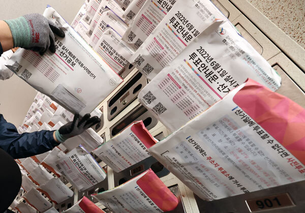 제8회 전국동시지방선거를 열흘 앞둔 22일 오전 서울 강서구의 한 아파트에서 집배원이 투표안내문 및 선거공보물을 우편함에 넣는 모습을 선보이고 있다. [사진 = 연합뉴스]