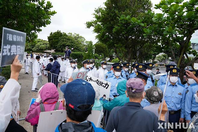 [오키나와=신화/뉴시스] 오키나와 일본반환 50주년을 맞은 15일 주일미군 철수를 요구하며 행진하는 시위대를 경찰이 막아서고 있다. 2022.05.18