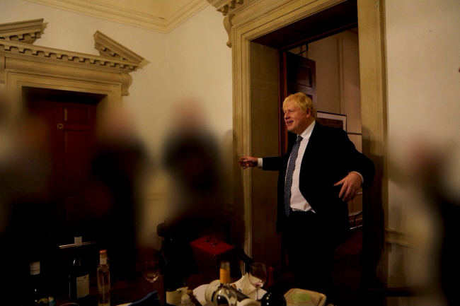 보리스 존슨 영국 총리가 2020년 11월 13일 런던 다우닝가 총리실에서 열린 파티에서 술잔을 든 채 직원들과 대화를 나누고 있다. 이 사진은 25일 공개된 ‘파티 게이트’ 조사 보고서에 증거로 첨부됐다. 로이터 연합뉴스
