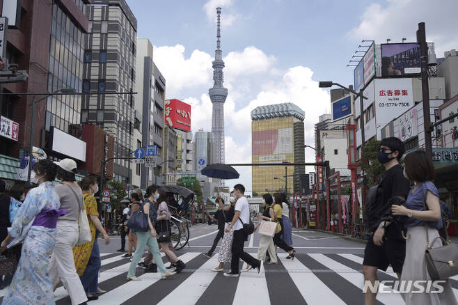 [도쿄=AP/뉴시스] 일본 수도 도쿄 번화가 아사쿠사에서 작년 7월31일 코로나19 예방을 위해 마스크를 착용한 시민들이 횡단보도를 건너고 있다. 2022.05.26