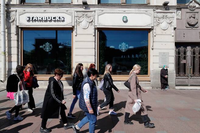 5월 24일 러시아상트 페테르부르크 도심의 문닫은 스타벅스 매장앞으로 시민들이 걸어가고 있다./EPA  연합뉴스