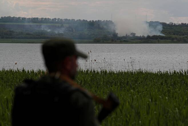 우크라이나 동부 도네츠크주의 노볼루한스케 외곽에서 한 친러시아 반군 대원이 치솟는 포연을 바라보는 모습. /연합뉴스