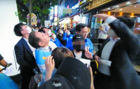 지난 20일 오후 인천 계양구 음식점 앞에서 유세를 위해 이동하던 더불어민주당 이재명 후보가 닭뼈통이 날아온 쪽을 쳐다보고 있다. [유튜브 채널 이재명 캡처]