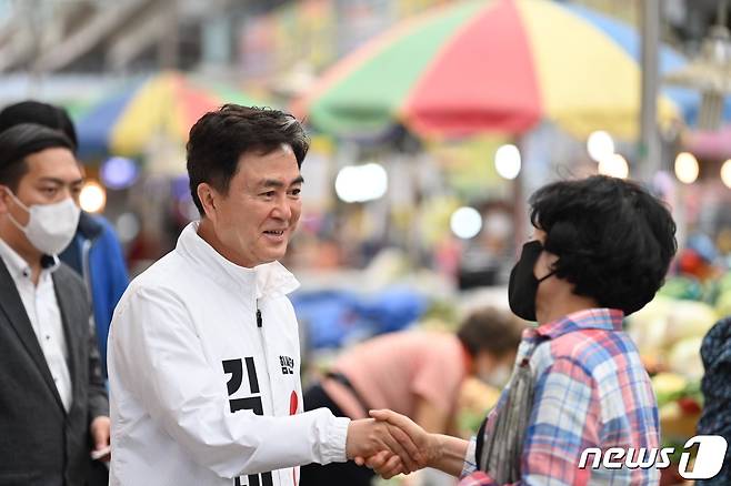 김태흠 후보가 28일 충남 천안중앙시장에서 만난 상인과 인사를 나누고 있다. © 뉴스1