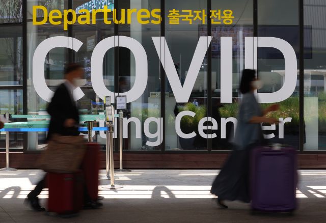 인천국제공항 제1여객터미널 코로나19 검사센터 앞에서 지난 27일 항공기 이용객이 지나가고 있다. 연합뉴스