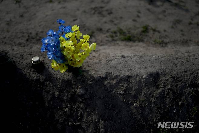 [부차=AP/뉴시스] 24일(현지시간) 우크라이나 키이우 외곽 부차의 공동묘지 한 묘소에 우크라이나 국기 색상으로 배열된 꽃이 놓여 있다. 2022.05.24.