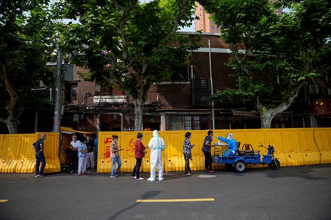 중국 상하이의 한 주택가에서 30일 주민들이 코로나19 검사를 받기 위해 줄을 서 있다. 로이터연합뉴스