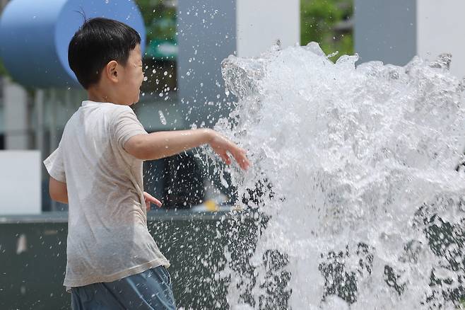 낮 동안 더위가 나타난 2일 서울 시청광장 분수대에서 어린이가 물놀이를 하고 있다. 연합뉴스