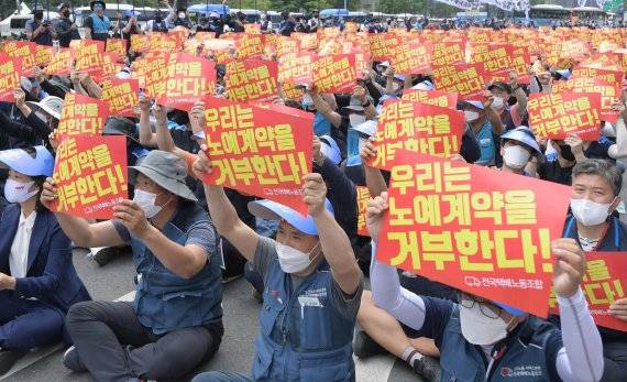 민주노총 서비스연맹 전국택배노동조합원들이 13일 서울 세종대로에서 열린 '임금삭감, 쉬운 해고 노예계약 저지' 우체국 택배 노동자 총력 결의대회에서 노예계약서를 거부하는 손 피켓을 들고 있다./사진=김범석 기자