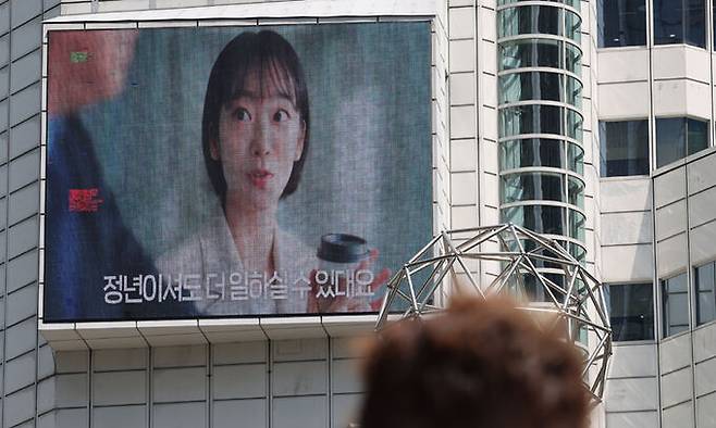 지난 5월 26일 합리적인 이유 없이 연령만을 이유로 직원의 임금을 깎는 '임금피크제'는 고령자고용법을 위반한 것이므로 무효라는 대법원의 판단이 나왔다. 사진은 이날 서울 중구 서울고용노동청 외벽 모니터의 고령자 계속 고용장려금 광고. 연합뉴스