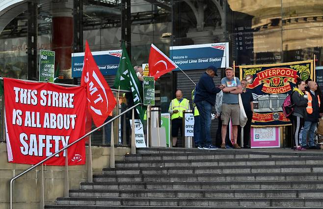 21일(현지시간) 영국 런던 리버풀역 앞에서 철도해운노조(RMT) 소속 노조원들이 파업 피켓을 걸고 시위를 벌이고 있다. (사진=AFP)
