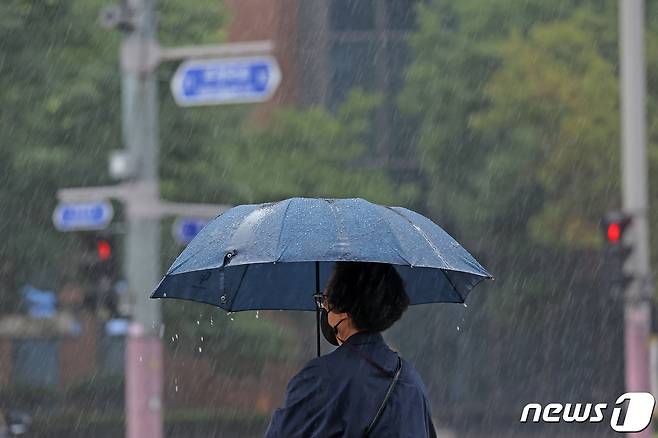 전국적으로 장마가 시작된 23일 거리에서 시민이 우산을 쓴 채 횡단보고 신호를 기다리고 있다. 2022.6.23/뉴스1 © News1 조태형 기자