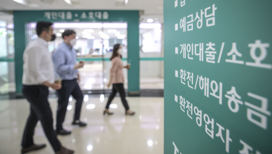 서울 시내 한 은행의 대출창구 옆을 직장인들이 지나고 있다. 뉴시스