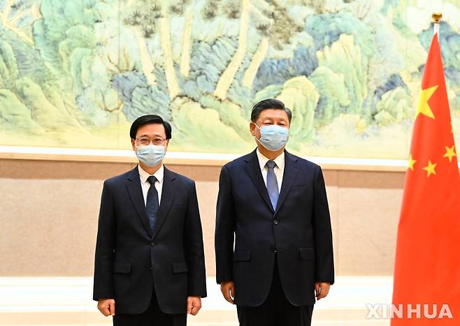 [베이징=신화/뉴시스] 시진핑(오른쪽) 중국 국가주석이 30일 베이징에서 존 리 홍콩 행정장관 당선인을 만나 기념 촬영을 하고 있다. 시 주석은 "새 행정부가 새로운 분위기를 조성해 홍콩 발전의 새로운 장을 열 것"이라며 "리 당선인이 국가 안보와 홍콩의 번영, 안정을 지키는 데 이바지하길 바란다"라고 말했다. 2022.05.31.