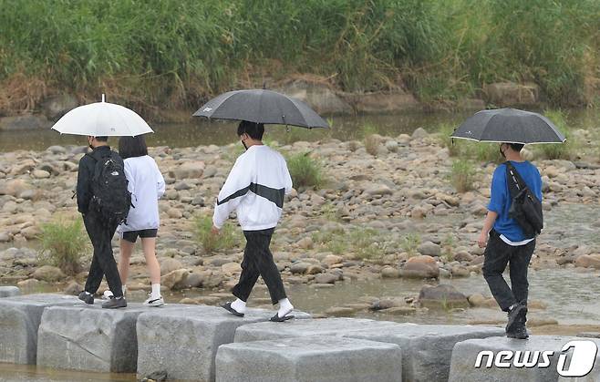 경남 거창군 거창읍 위천천 징검다리에 우산을 쓴 주민들이 지나고 있다.(거창군 제공) 2022.6.5/뉴스1