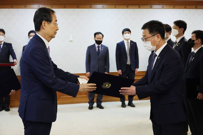 한덕수 국무총리가 8일 정부서울청사 의전행사실에서 윤수현 공정거래위원회 부위원장에게 임명장을 주고 있다. /연합뉴스.