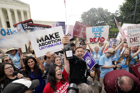 미국 연방 대법원이 낙태권을 보장했던 과거 판결을 폐지한 24일(현지시간) 대법원 앞에서 낙태금지 지지자들이 환호하고 있다. AP
