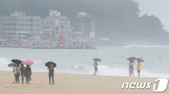 부산 해운대해수욕장을 찾은 관광객들이 우산을 쓰고 바다를 바라보고 있다. 2018.6.28/뉴스1 © News1