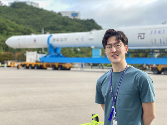 '나로호 키즈'로 우주 개발자 꿈을 실현한 오영재 한국항공우주연구원 연구원이 누리호를 배경으로 사진을 찍고 있다.            오영재 연구원 제공