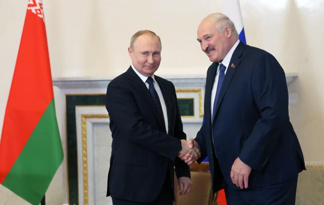 블라디미르 푸틴(왼쪽) 러시아 대통령과 알렉산드르 루카셴코 벨라루스 대통령이 25일 상트페테르부르크에서 회담하는 도중 악수를 나누고 있다. 푸틴 대통령은 이날 벨라루스에 핵탄두를 탑재할 수 있는 미사일 시스템을 전달하겠다는 계획을 밝혔다. 상트페테르부르크=EPA 연합뉴스