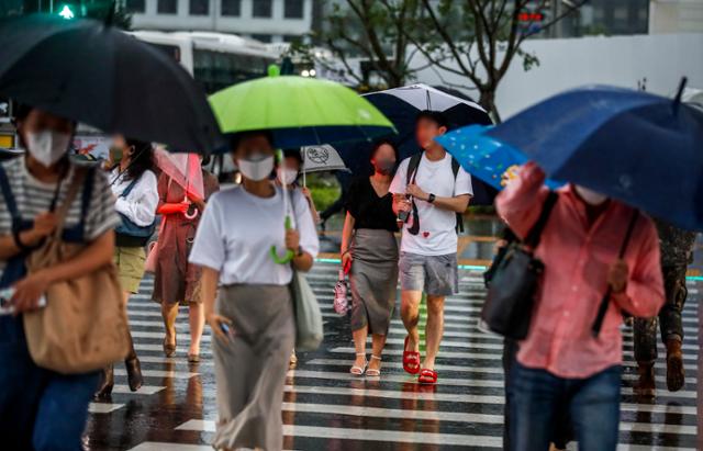 전국적으로 장맛비가 내린 23일 서울 종로구 광화문광장 인근에서 시민들이 우산을 쓴 채 발걸음을 옮기고 있다. 뉴시스