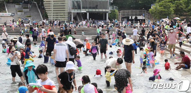 서울 여의도 한강공원 물빛광장 분수대에서 나들이객들이 물놀이를 즐기며 더위를 식히고 있다.© News1 임세영 기자