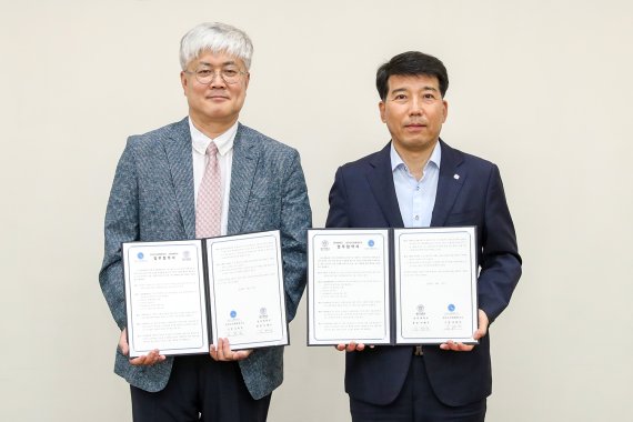 이해우 동아대 총장(오른쪽)과 김현민 국가수리과학연구소 소장이 업무 협약서를 들고 기념사진을 찍고 있다./제공=동아대학교