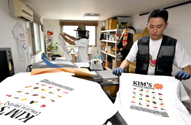 김씨네 과일가게에서는 작은 사무실에서 티셔츠를 찍어낸다. 22일 김도영(오른쪽)씨와 조용일(왼쪽)씨가 함께 프린트작업을 하고 있다. 왕태석 선임기자