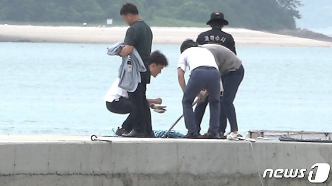 경찰이 완도 송곡항 인근 바다에서 건저올린 아우디 승용차 부품 일부를 확인하고 있다. © 뉴스1