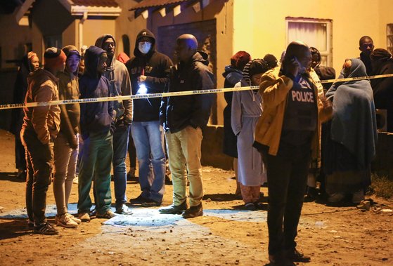 26일(현지시간) 10대 20여명이 집단 의문사한 남아프리카공화국 이스트런던의 한 술집 앞에서 유가족들이 경찰의 발표를 기다리고 있다. AFP연합뉴스