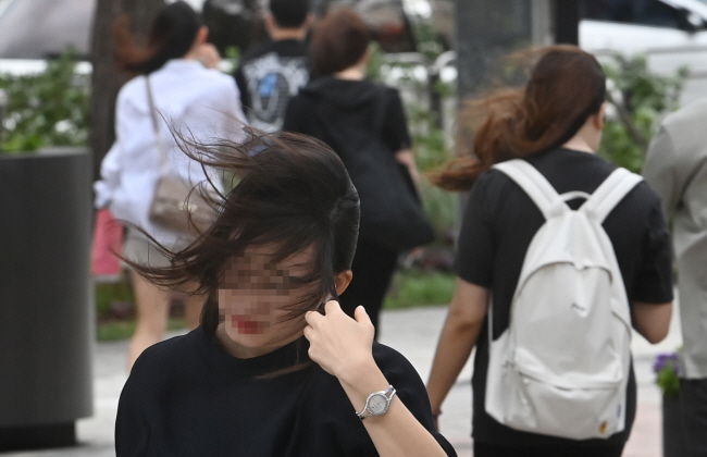 머리카락 휘날리고… : 28일 오전 서울 중구 남대문로 거리에서 출근길 시민들이 강풍에 흩날리는 머리카락을 가다듬고 있다. 신창섭 기자