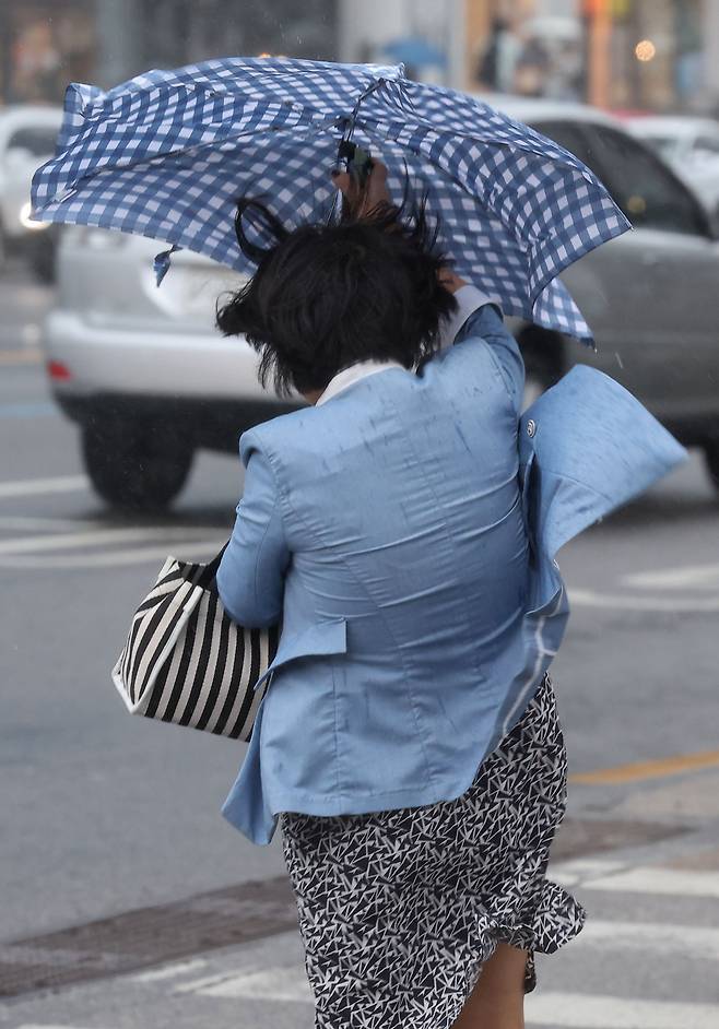 서울에 강풍을 동반한 소나기가 내린 28일 오후 서울 마포구 지하철 홍대입구역 인근 횡단보도에서 시민들이 비바람을 맞고 있다. [연합]