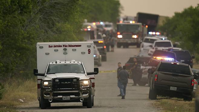 27일(현지시간) 대형 트레일러 안에서 시신이 무더기로 발견된 미국 텍사스주 샌안토니오 남서부 외곽에서 구급차 한 대가 떠나고 있다. AP연합뉴스