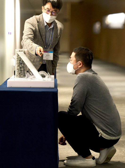 구광모 LG 회장이 28일 서울 마곡 LG사이언스파크에서 무릎을 꿇고 LG화학 직원으로부터 촉매를 활용해 탄소를 저감하는 기술에 대해 설명을 듣고 있다. (사진=LG)